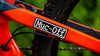 Muc-off sticker on orange bike frame