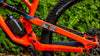 Black and white muc-off sticker on orange bike frame