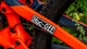 Close up of muc-off sticker stuck to an orange bike frame